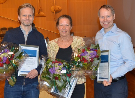 Bilde av tre prisvinnere, oppstilt smilende med diplomer og blomster i hendene.