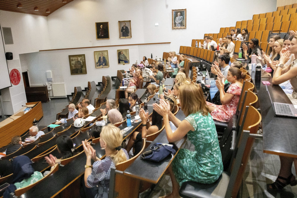 Studenter applauderer hverandres presentasjoner i auditorium